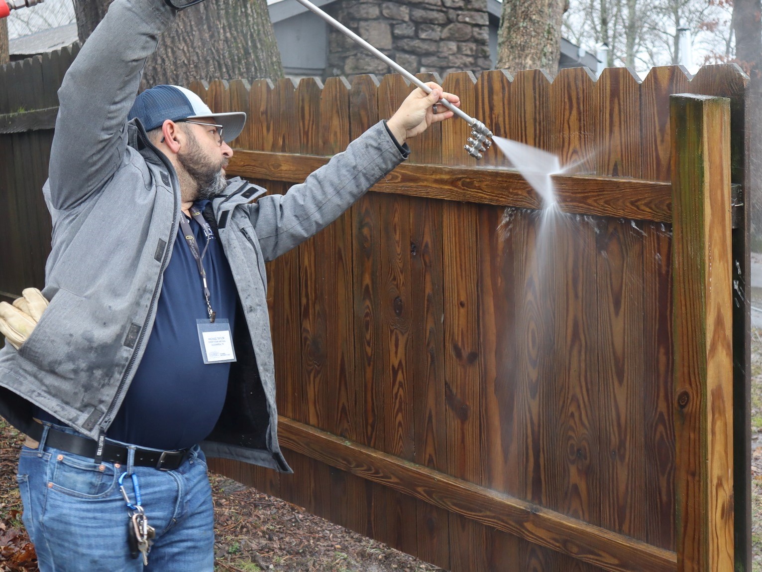 Photo of a man pressure washing a wood fence to prepare for staining in Nashville, Tennessee